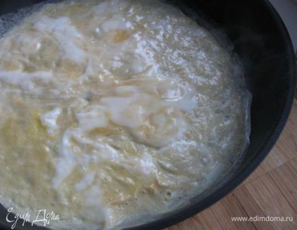 Смазать маслом  и раскалить сковороду,  вылить часть массы на сковороду, убавить огонь до среднего и выпечь яичный блинчик. Он тонким слоем должен заполнить всю сковородку. Если появятся пузыри (их быть не должно), значит температура  сковороды слишком высокая. Мастера говорят, что ключ к лёгкой текстуре омлета заключается в поддержании должной температуры сковороды.