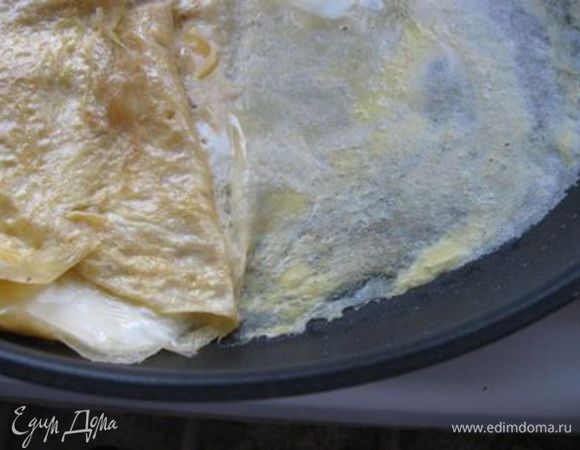 Влить новую порцию яичной смеси на освободившееся место и чуть приподнять уже сделанный рулет так, чтобы яичная масса  попала частично и под него. Яичный блинчик должен «приклеиться к рулету». Рулет поддеваем лопаткой или палочками и переворачиваем на новый яичный блин. На освободившуюся пустую часть сковороды выливаем еще порцию яичной смеси. Проделываем ту же процедуру в обратном направлении. Повторять операцию до тех пор, пока не израсходуется вся яичная масса. Снять омлет с огня. 

