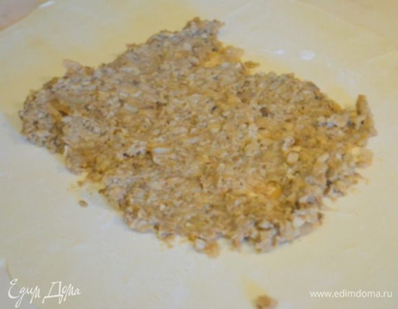 Тесто разрезаем на 2 части – одна чуть больше – это основа, а вторая – поменьше – крышка. Основу сразу перенести на коврик для выпекания и мясо собирать непосредственно на нем.На основу в центр кладем ½ грибной смеси по размеру куска мяса.