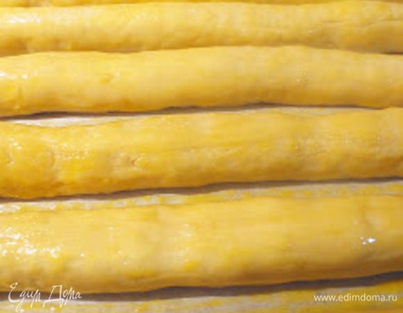 Взбить яичный желток и смазать им колбаски. Оставить на пол часа.