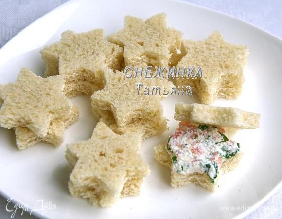 Петрушку моем, просушиваем, измельчаем ножом. Вместе с рыбой добавляем к сырной массе, перемешиваем. На один кусочек хлеба кладём немного начинки, накрываем вторым кусочком. Соединяем попарно все канапе.