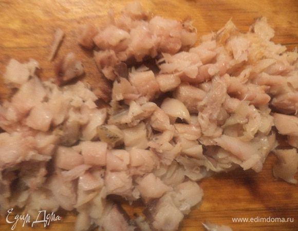 Копчёную рыбку отделить от кожи и костей. Нарезать кубиками.
Порезать колечками зелёный лук.