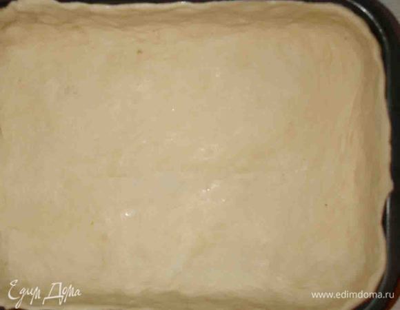 Когда тесто уже готово, формируем пирог. Разделяем на две части. Одну — больше, другую — меньше. Оставляем кусочек для украшения. Тесто раскатываем не толсто и выкладываем им форму.