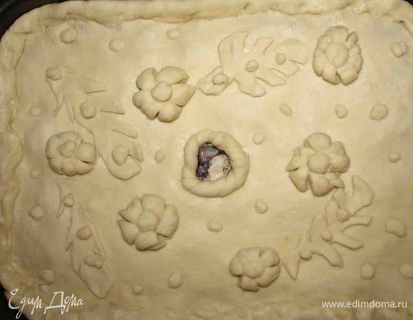 Выкладываем часть начинки, на нее — лук с фасолью, сверху — остальную начинку и закрываем другой половиной теста. Скрепляем края, в середине делаем отверстие. Украшаем. Даем постоять пирогу 10 минут. В отверстие наливаем бульон. Взбиваем яйцо и смазываем пирог.