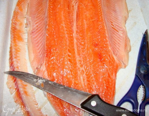 Удалить плавники, хребет и кости, не повредив кожу.