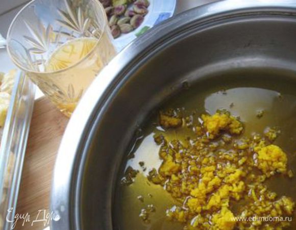 Растопить мёд в широкой кастрюле вместе с  сахаром, соком и цедрой апельсина. Довести до кипения. Цукаты порезать и опустить в мед. Перемешать. Фисташки измельчить и добавить в массу. Убавить огонь. 