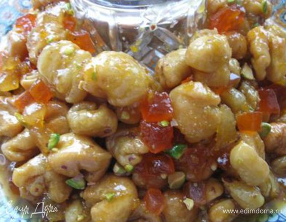 В блюдо поставить стакан и вокруг него разложить струффоли, придав форму венка. Не нужно поливать наш венок из струффоли сверху, даже немного, т.к. сложно проконтролировать внутри количество и места пропитки, в результате лишний мёд стечет вниз. Лучше пусть останется какое-то количество карамели неиспользованной. 