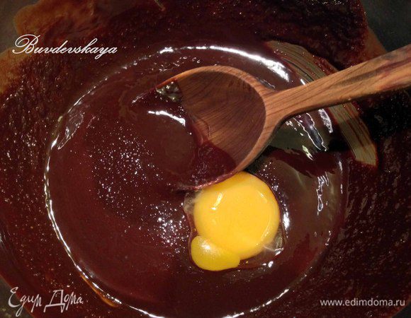 Всыпаем в миску с шоколадной массой сахарный песок и перемешиваем. Добавляем по одному желтки, а затем и целое яйцо. Перемешиваем. Добавляем просеянную муку с разрыхлителем и тщательно перемешиваем, чтобы не было комочков. 