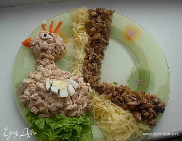 Мы подготовили все ингредиенты, начинаем выкладывать птичку.
Из мяса делаем туловище, голову и шею.Носик и корону Делаем из моркови. Крылышко - кусочек варенного яйца, глаз - белок яйца и перчинка. 
После того как птица готова- делаем ей хвост. выкладываем сегментами подготовленные ингредиенты.