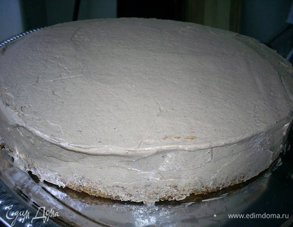 Теперь кладем оставшийся пласт бисквита, срезом на крем. Таким образом верхом торта стало дно бисквита.  Обмазываем верх и бока торта шоколадным кремом. 