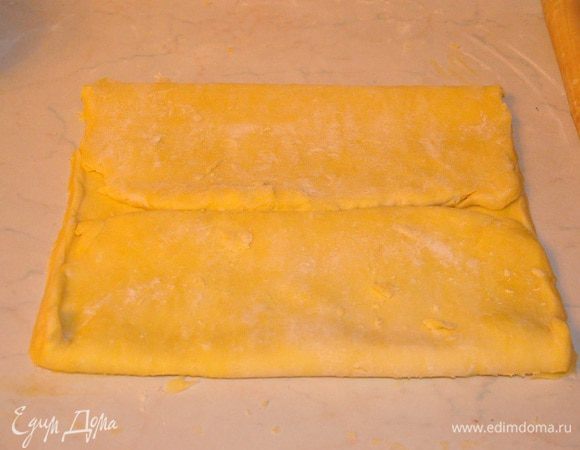 Вынуть из холодильника, раскатать в прямоугольник со сторонами примерно 50 см на 17 см. В общем -то, сантиметры не важны, просто раскатывайте так, чтобы длина должна была больше чем ширина в 3 раза, а толщина теста примерно 1см. 