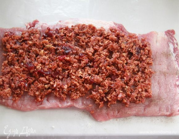 Подготовленный пласт свинины посолить, поперчить, выложить начинку, не выкладывая до края на 3 см.