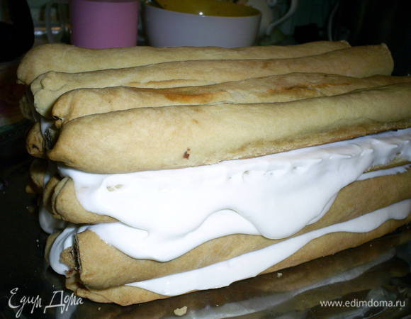 Затем еще три ряда по четыре трубочки, которые щедро перемазываем кремом. Далее будем уменьшать количество трубочек в ряду, чтоб получить крышу. Выкладываем три трубочки и смазываем их кремом.