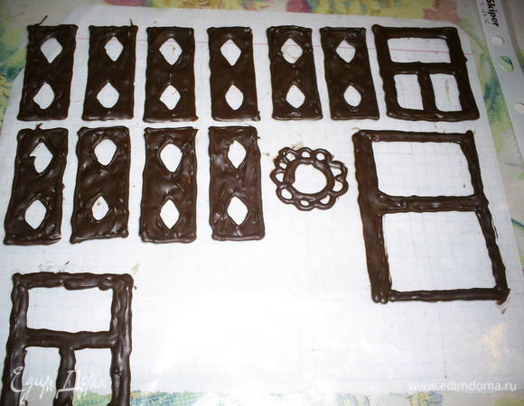 Я заранее растопила черный шоколад и нарисовала на файле окна, ставни и двери для пущей реалистичности. Их размер зависит от ваших пожеланий и размеров домика. По моей задумке детальки должны были быть двухцветными. Те фрагменты, которые должны быть белыми, пока оставляем незаполненными.