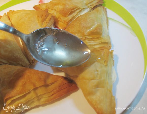 Перекладываем горячие пирожные на тарелку и поливаем сиропом.