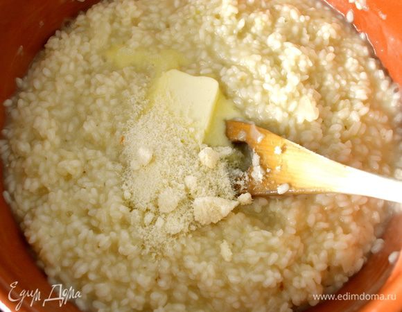 За 2 минуты до окончания приготовления ризотто добавить в него немного сливочного масла и 50 г тертого сыра.