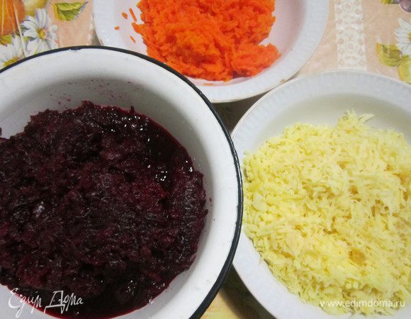 Овощи сварить и охладить в холодильнике 2-3 часа. Это делается для того, чтобы после измельчения они не слипались. Овощи очистить и натереть на мелкой терке. Натёртую свеклу и морковь нужно обязательно отжать.