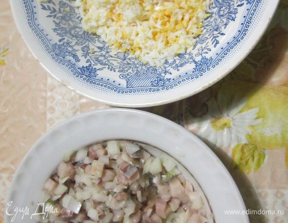 Лук мелко нарезать. Филе сельди нарезать маленьким кубиком, добавить лук и перемешать. Яйца сварить, очистить и натереть на мелкой терке. 
