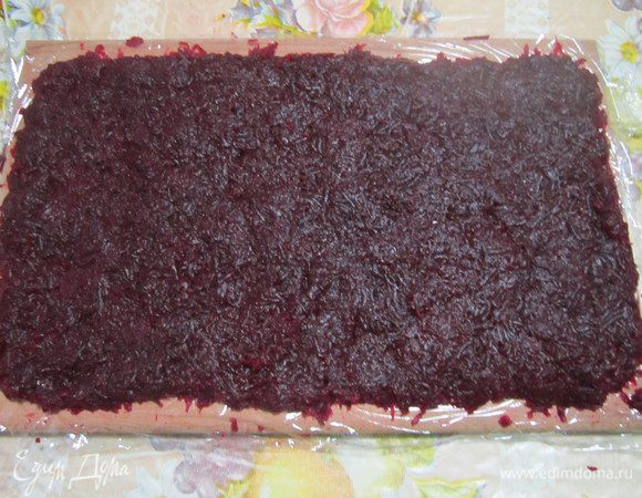 Натертую свеклу выложить слоем на пищевую пленку, посолить и слегка уплотнить руками. Майонезом не смазывать, чтобы рулет хорошо сохранял форму. 