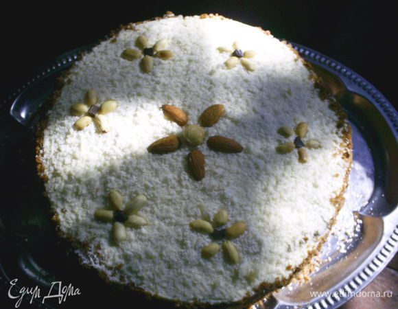 Верх я посыпала кокосовой стружкой, а бока - крошкой, оставшейся при разрезании коржей. Украшаем орехами.