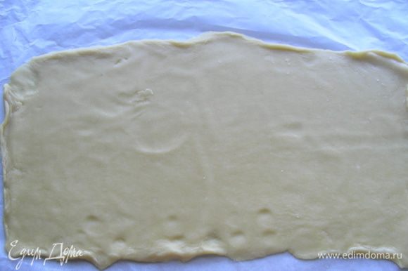 Тесто раскатываем в прямоугольник - примерно 35х20 см, можно покороче (а ширину 20 см лучше сохранить). Слишком тонко раскатывать не стоит, иначе потом тесто может порваться при складывании. Удобно его раскатывать на бумаге для выпечки.
