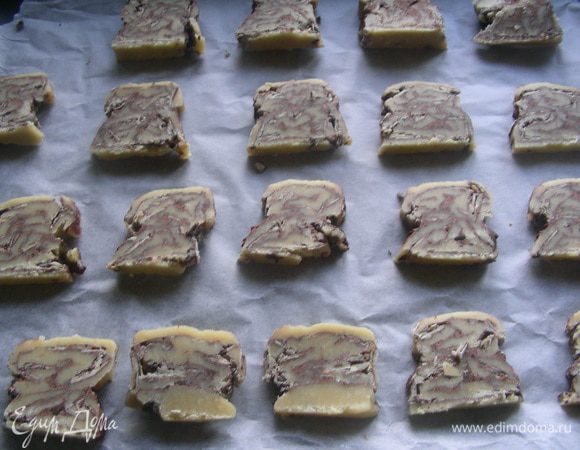 Достаем нашу заготовку и режем ее на кусочки толщиной 0.5 см. Выкладываем их на противень, застеленный бумагой для выпечки.
