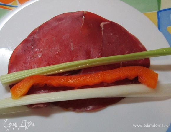 На край брезаолы выложить брусочки овощей. Свернуть рулетом.
Завязать зеленым луком.
Подавать!
