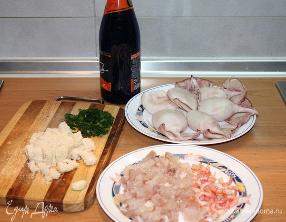 Кальмары опустить в кипящую воду на 1 минуту, почистить, удалить внутренности и обрезать хвостики. Креветки опустить в кипяток на 2 минуты, почистить и порезать на кусочки. Филе масляной рыбы тоже порезать на кусочки. Срезать корочку у белого хлеба, мякиш порезать на кусочки. Петрушку и чеснок  мелко порезать.