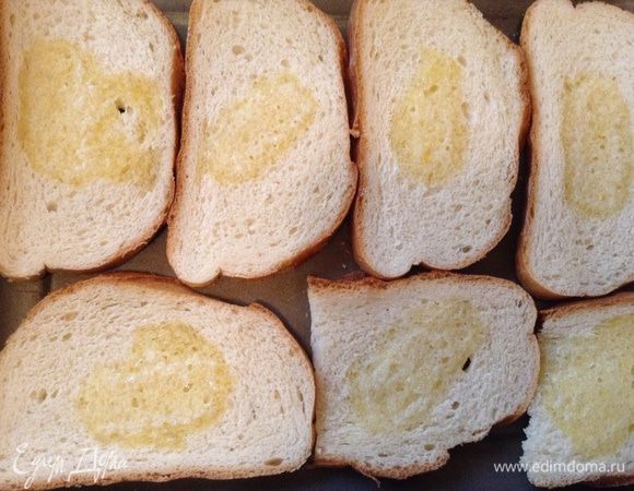 Хлеб уложить на протвень, на середину каждого положить небольшой кусочек сливочного масла и поставить в разогретую до 200 градусов духовку минут на 5-7.