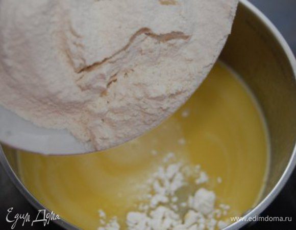 Сотейник снять с огня, частями добавить просеянную муку, непрерывно мешая деревянной лопаткой. 
