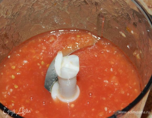 Консервированные томаты очистить от кожуры, добавить очищенные зубчики чеснока, измельчить в блендере.