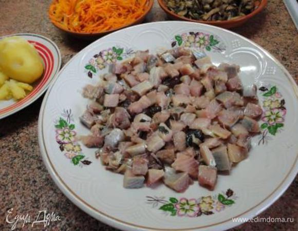 Сельдь разделать на филе, нарезать кусочками и выложить на дно блюда.