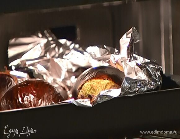 Небольшую глубокую форму выстелить пищевой фольгой, выложить баклажаны, наколоть их вилкой и отправить в разогретую духовку. Когда баклажаны запекутся сверху, перевернуть их и продолжать запекать до образования румяной корочки.