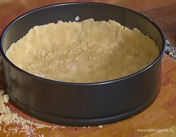 Частями выложить тесто в разъемную форму для выпечки, распределяя его тонким слоем по дну и стенкам, чтобы получились высокие бортики. Отправить форму с тестом на час в холодильник или на 15–20 минут в морозилку.