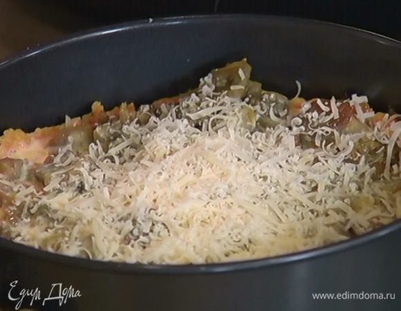 Подпеченный корж вынуть из духовки, выложить на него куриный фарш, слегка утрамбовать, сверху распределить кусочки баклажанов, полить заливкой и дать ей впитаться, затем посыпать оставшимся сыром.