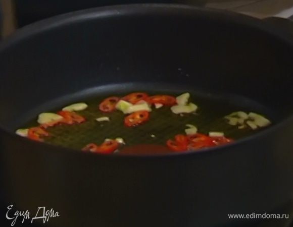 Разогреть в сковороде оливковое масло, выложить чеснок и чили и обжаривать, пока чеснок не станет прозрачным.