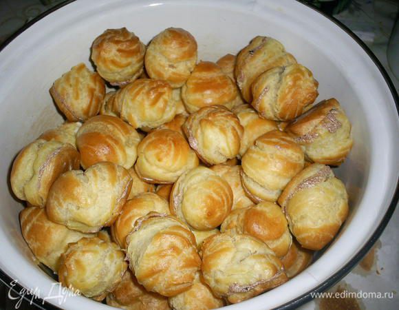 Заполняем пирожные кремом (половину профитролей белым, половину - шоколадным) при помощи кондитерского мешка. Или срезаем донышко и крем накладываем чайной ложечкой.