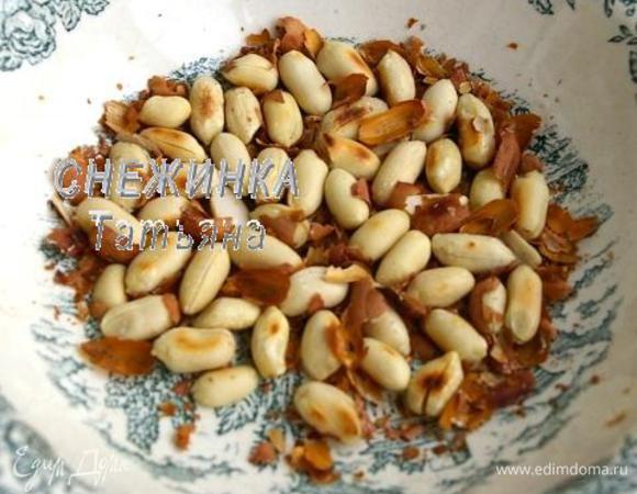Подготовим орехи. Арахис обжариваем на сухой сковороде до румяного цвета. Затем даём ему остыть и счищаем кожечку. Она легко отшелушивается, если потереть орешек между пальцев.