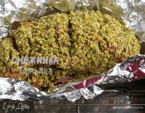 Свинину кладём на лист фольги. Щедро обмазываем верх и бока ореховой пастой. Плотно заворачиваем в фольгу и кладём на противень или в форму для запекания.