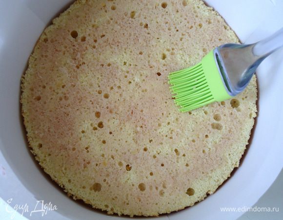 На дно формы положить первый корж, пропитать его сиропом.
