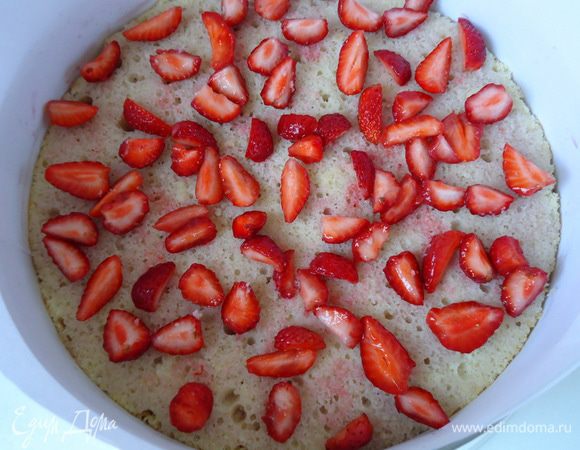 Третий корж положить поверх крема, пропитать. По его поверхности разложить нарезанную клубнику. У меня было ограниченное количество, можно ягод добавить побольше. 
