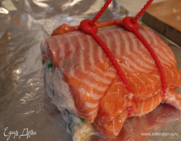 Выложить сверху вторую половину фарша, накрыть вторым филе и сформировать рулет. Закрепить при помощи силиконовых зажимов. 