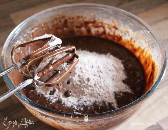 В отдельной миске смешать муку, какао, соль и разрыхлитель. Порциями подмешать муку к жидкому тесту.