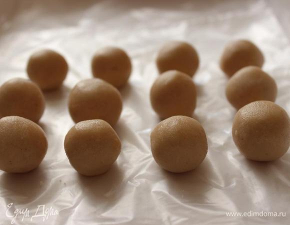 Тем временем можно сделать конфеты. Для этого растереть арахисовую пасту со сливочным маслом и сахарной пудрой. Затем в массу замешать измельчённое в блендере печенье (я использовала растёртые в муку савоярди). Скатать арахисовую массу в шарики, размером с грецкий орех (или чуть меньше). Охладить шарики в морозильнике в течение 30 минут.
Я встречала рецепт подобных конфет с добавлением обычного крахмала, вместо печенья. Такой вариант я тоже попробовала. Крахмал совершенно не чувствуется и конфеты очень похожи на халву в шоколаде.