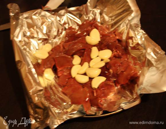 Печень очищаем от пленок. Кладем в форму для запекания,застеленную фольгой. Духовку разогреваем до 180 градусов. Туда же кладем очищенный чеснок. Заворачиваем плотно фольгу и запекаем 40 минут. Остужаем.