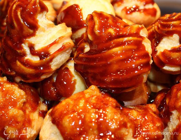 Варим карамель, как указано выше. Обмакиваем профитроль одним боком в карамель и ставим его на торт. Начинаем с больших. 