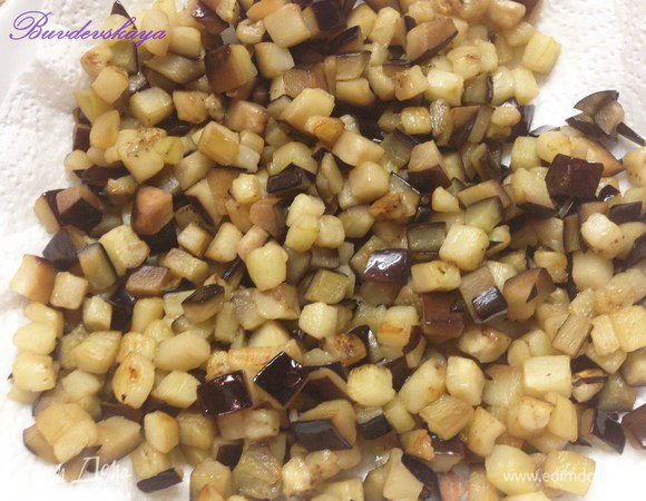 Баклажаны вымыть (если у баклажан толстая жесткая кожица, то ее лучше срезать), обсушить, нарезать мелкими кубиками, слегка присыпать солью, перемешать и оставить на полчаса, чтобы они дали сок. После этого переложить в дуршлаг, промыть, дать стечь воде и обжарить на небольшом количестве растительного масла до готовности (они не должны превратиться в кашу). Выложить на бумажное полотенце, чтобы впиталось лишнее масло.