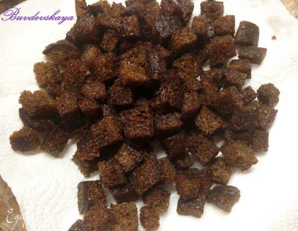 Хлеб нарезать кубиками чуть большего размера чем баклажаны (если у хлеба жесткая корка- срезать ее). Обжарить кубики бородинского хлеба на растительном масле, чтобы сверху образовалась хрустящая корочка, а внутри оставались мягкими. Также выложить на бумажное полотенце. 