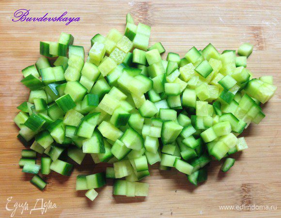 Огурец вымыть, обсушить и нарезать мелкими кубиками. Шпроты вынуть из масла и выложить на бумажное полотенце, чтобы впиталось масло.