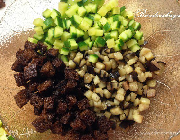 В миске смешать баклажаны, хлеб (отложить несколько кусочков для украшения) и огурец, добавить немного майонеза, пропустить чеснок через пресс. Посолить, поперчить по вкусу.